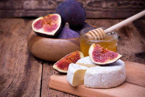 Formaggio Camembert con miele e fichi su una tavola di legno . — Foto Stock