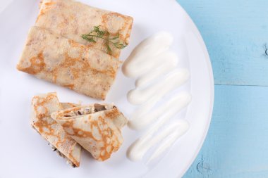 Tepesinde ekşi krema ile doldurulmuş krep.