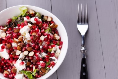 Sağlıklı salata nar taneleri, badem, beyaz peynir ve siyah pirinç