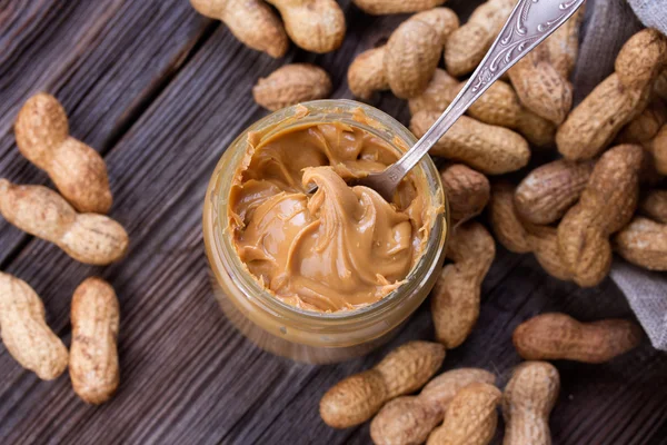 Fresh made creamy Peanut Butter in a glass jar — Stock Photo, Image