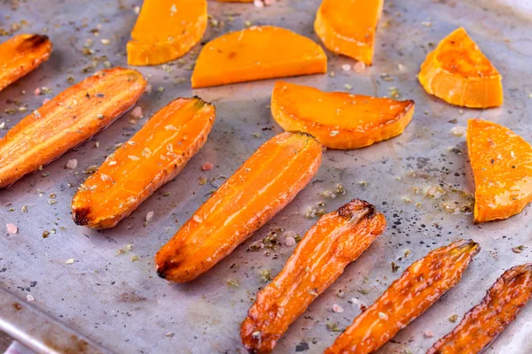 Geroosterde pompoen en wortel op goed gebruikte oven bakplaat — Stockfoto