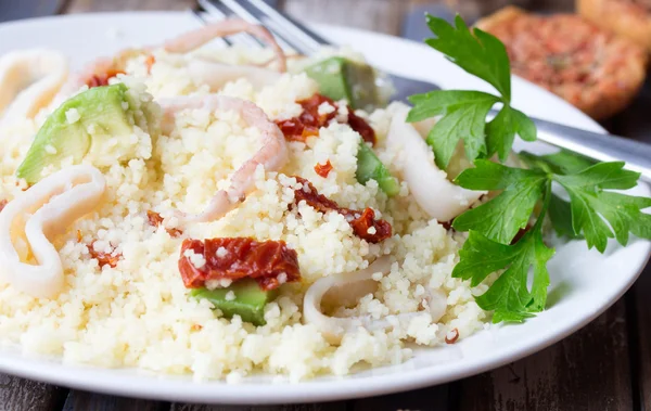 Couscous met zeevruchten, gedroogde tomaten, avocado en weinig toast — Stockfoto