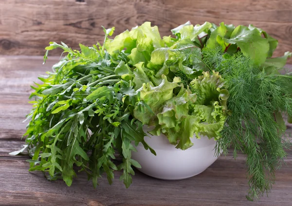 Variedad de hierbas orgánicas frescas sobre fondo de madera en estilo rústico. Lechuga, rúcula, eneldo . —  Fotos de Stock