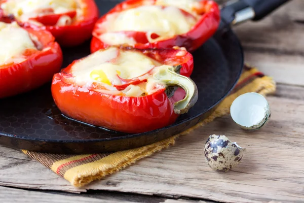 Red pepper stuffed with pasta and cheese on old wooden table — Stock Photo, Image