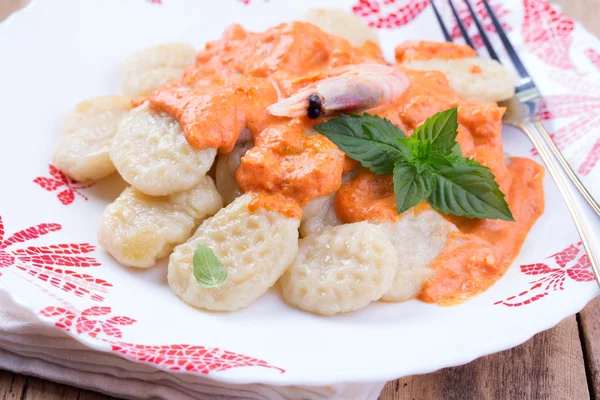 Gnocchi with tomato sauce and basil on a tablecloth — Stock Photo, Image