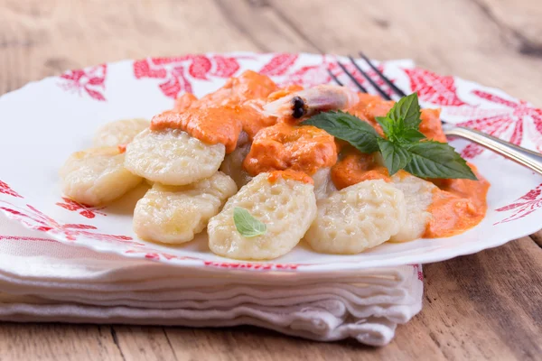 Gnocchi with tomato sauce and basil on a tablecloth — Stock Photo, Image
