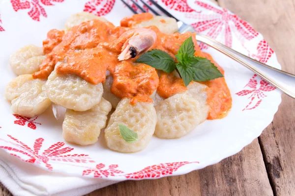 Gnocchi with tomato sauce and basil on a tablecloth — Stock Photo, Image