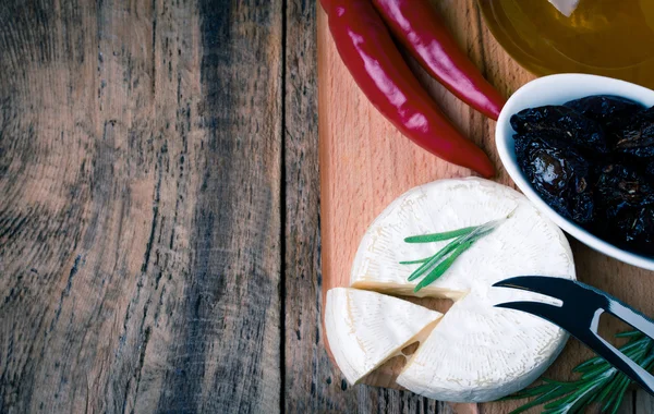 Queijo brie na velha mesa de madeira — Fotografia de Stock