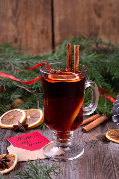 Glühwein, gesneden gedroogde oranje, kaneelstokjes, anijs sterren en kaars met pine brunch — Stockfoto