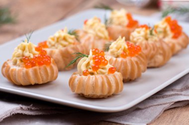 bir plaka üzerinde kırmızı havyar ile doldurulmuş profiterol