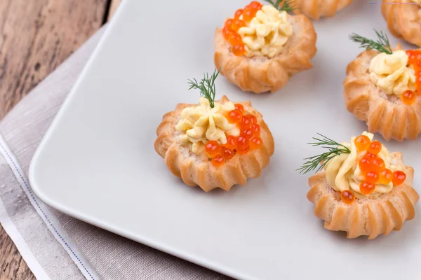 Profiteroles stuffed with red caviar on a plate — Stock Photo, Image