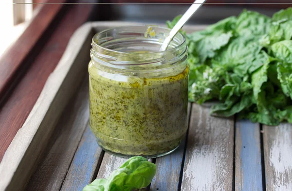 Pesto caseiro em uma bandeja de madeira rústica — Fotografia de Stock