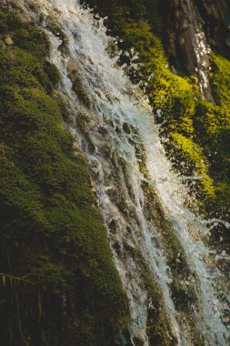 Nehirden gelen temiz ve şeffaf su. Jura, Fransa. Arbois yakınlarındaki tufa şelalesi. Kristal berrak şelale.