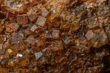 Parlak, açısal kristaller bir kaya parçasında görülebilir. Işık onların dokusunu ve rengini vurgular. Bu mineral oluşumu büyüleyici ve ilgi çekici..