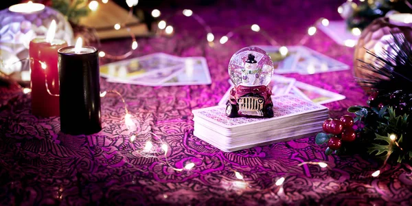 Blurred Tarot cards on table near burning candles. Tarot reader or Fortune teller reading on Christmas decoration. . High quality photo