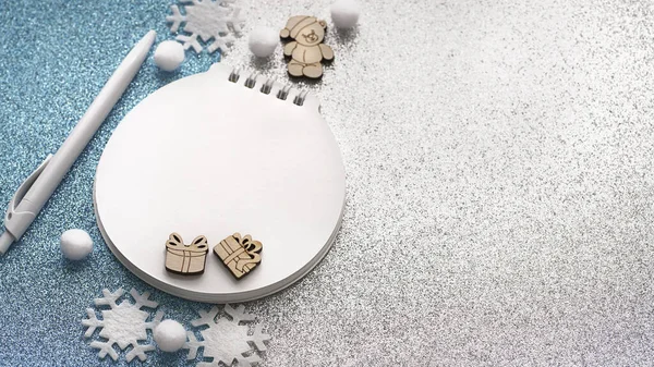 ノートパッドと燃えるクリスマスの組成 光沢のある背景に雪の結晶をペンします 高品質の写真 — ストック写真