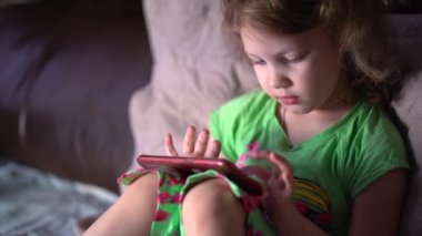  Küçük kız akıllı telefondan oyun oynuyor..
