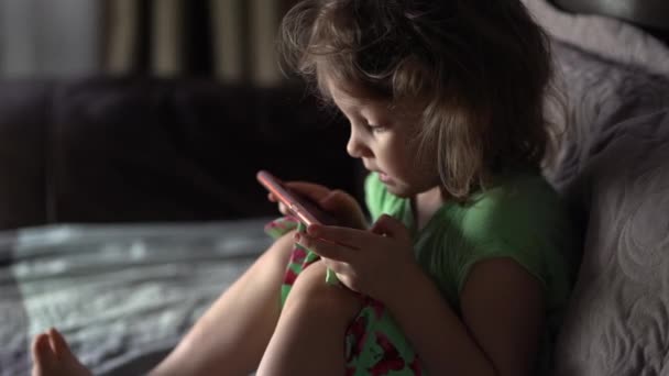 Pequena filha joga jogos no smartphone. — Vídeo de Stock