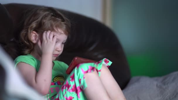 Meisje kijken cartoon met behulp van tablet. kleine dochter speelt games op de smartphone. — Stockvideo