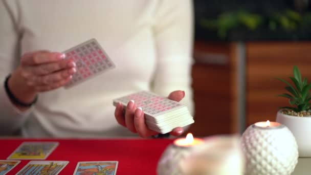 Tarjetas del tarot en la mesa cerca de velas encendidas. Lectura y pronóstico de la fortuna. — Vídeos de Stock