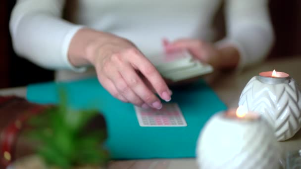 Cartas de tarô na mesa perto de velas acesas. Leitura e previsão da sorte. — Vídeo de Stock