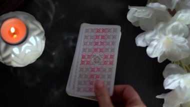 Tarot kartları yanan mumların yanındaki masada. Fal okuma ve tahmin.