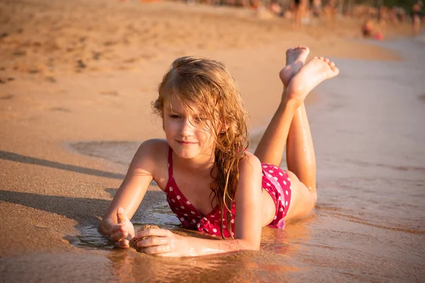 Девочка 7 лет загорает на берегу моря. Летняя концепция. Селективный фокус — стоковое фото