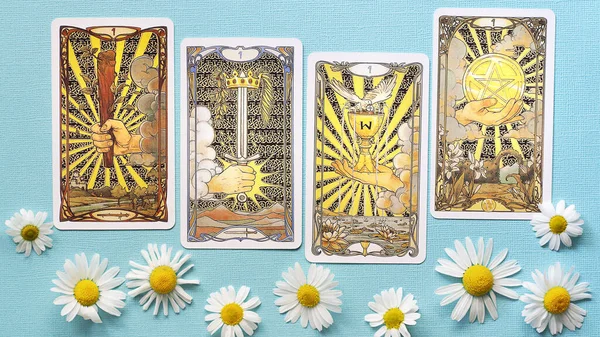 Cartas doradas del tarot sobre el fondo azul con flores de margarita, cuatro ases —  Fotos de Stock