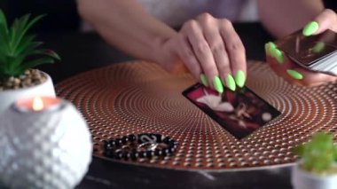 Masadaki tarot kartının bulanık görüntüsü, falcı kadın tarot kartlarıyla geleceği okuyor. Esrarengiz kavram, falcılık ve tahminler