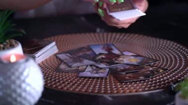 Masadaki tarot kartının bulanık görüntüsü, falcı kadın tarot kartlarıyla geleceği okuyor. Esrarengiz kavram, falcılık ve tahminler