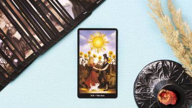 Moskova, Rusya - Temmuz 2021: Tarot kartı Mavi zemin üzerinde Güneş, esrarengiz kavram, falcılık ve tahminler