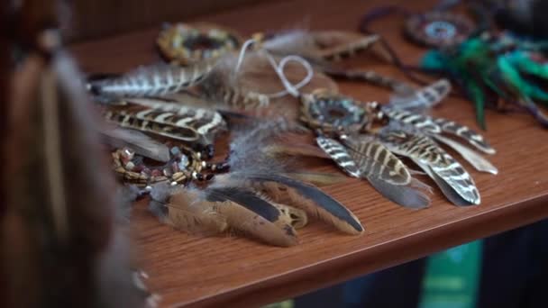 Ловцы снов из перьев кожаные бусины и веревки на полке в магазине — стоковое видео