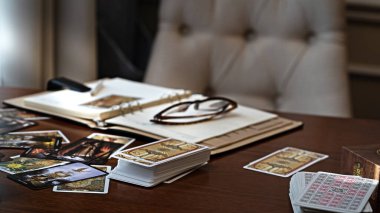 Tarot kartı okuyucusu kartları bir kart dağıtımında düzenler. Masada geleneksel tarot kartlarında fal baktırmak. Seçici odak, Moskova, Rusya-Haziran 2021.