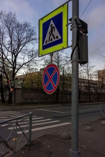A pedestrian crossing and road sign denotes crossing and prohibition of stopping cars due to pedestrians in urban environments. — Stock Image Pedestrian Crossing Road Sign Denotes Crossing Prohibition Stopping Cars Due Royalty Free Stock Photos