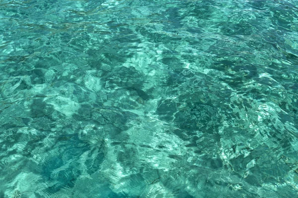 Textura de água azul, com ondulações e reflexos solares — Fotografia de Stock