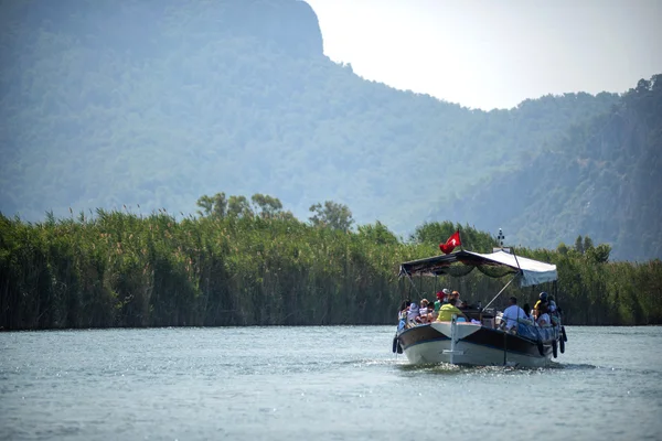 TURQUÍA, DALYAN, MUGLA - 19 DE JULIO DE 2014: Barcos de río turístico con turistas en la desembocadura del río Dalyan — Foto de Stock