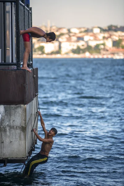 ISTANBUL - 5 de agosto: Los adolescentes saltan al mar del Bósforo desde la madera — Foto de Stock