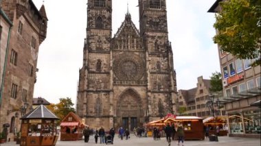 NUREMBERG, GERMANY - 18 Ekim 2020: St. Lorenz Kilisesi, zaman aşımı görüntüleri, yoldan geçen insanlar (St. Lawrence), gotik kilise
