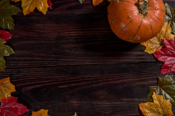 Fondo oscuro de madera con hojas de arce en los bordes y calabaza. espacio para notas —  Fotos de Stock