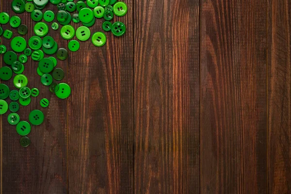 Groene knoppen van verschillende afmetingen zijn verspreid in de hoek van de houten achtergrond met ruimte voor tekst. Plattegrond — Stockfoto