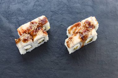 Teriyaki soslu rulo. Rulo ve suşi. Avokado, pilav, yılan balığı. Yılan balığı sarması. yemek servisi.