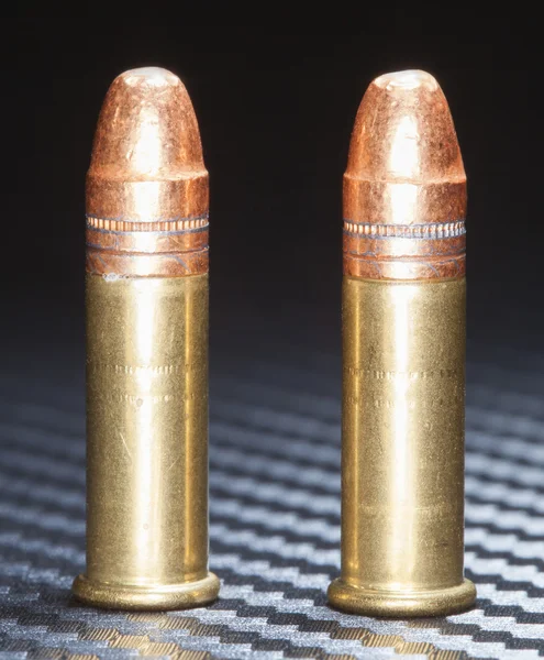 Copper bullets on graphite — Stock Photo, Image