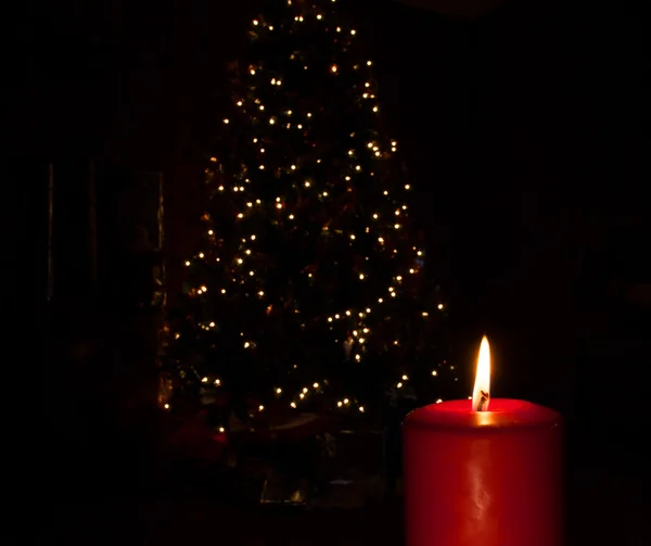 Vela ardiendo junto a un árbol de Navidad — Foto de Stock