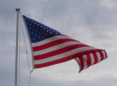 Rüzgâr, Amerikan bayrağının kıvrılmasına neden oluyor.