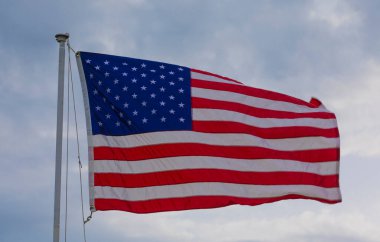 Amerikan bayrağı hafif bulutlarla rüzgarda hareket ediyor