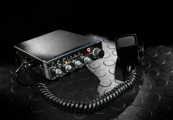 Two way radio on the emergency channel with a dark background on a rubber mat