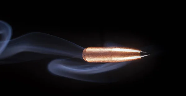 黒い背景を飛ぶ銅弾の後ろの煙 — ストック写真