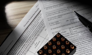 Kamu malı FBI NICS sabıka kaydı kontrol formu. Üstünde kalem ve mühimmat var.. 