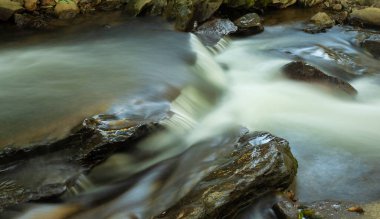 Güneş battıktan sonra Kuzey Carolina 'daki Boone yakınlarındaki büyük kayaların üzerinden akarsu akıntısı