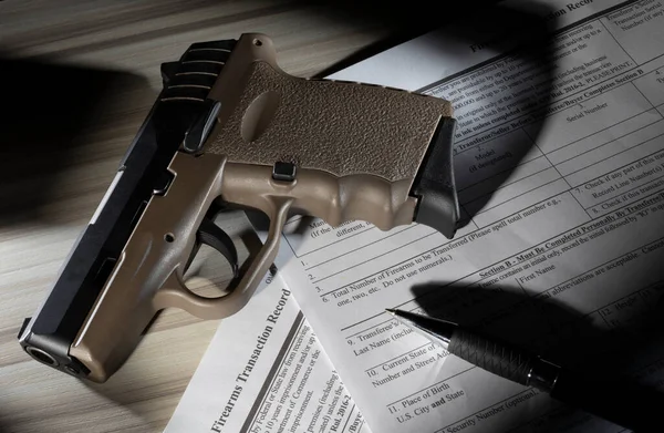 美国联邦调查局Nics背景调查表上的Tan聚合物半自动手枪 — 图库照片
